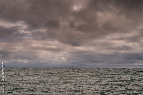 Obraz na płótnie Dark storm clouds over ocean. Dramatic seascape. Clouds and rain flurry over sea. w salonie