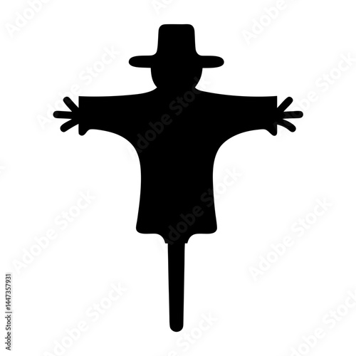 Black silhouette of a scarecrow wearing a hat standing in a field