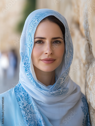 Woman in traditional attire near ancient stone wall