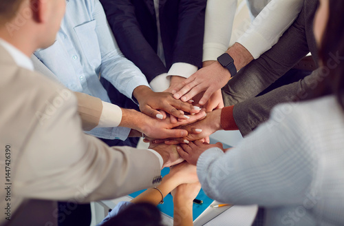 Business multicultural people join hands and place them on top of each other close-up. Concept solidarity and team support, teamwork of colleagues, community, corporate unity, merger photo