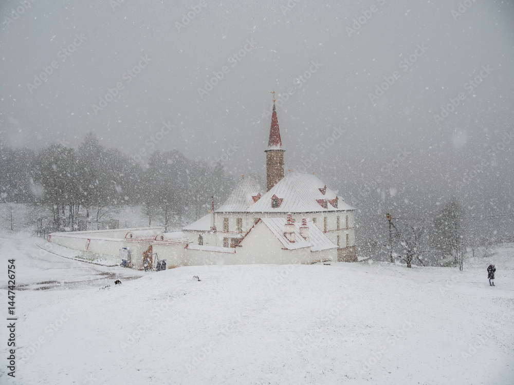 Fototapeta premium Gatchina Priory Palace in spring. Heavy snowfall