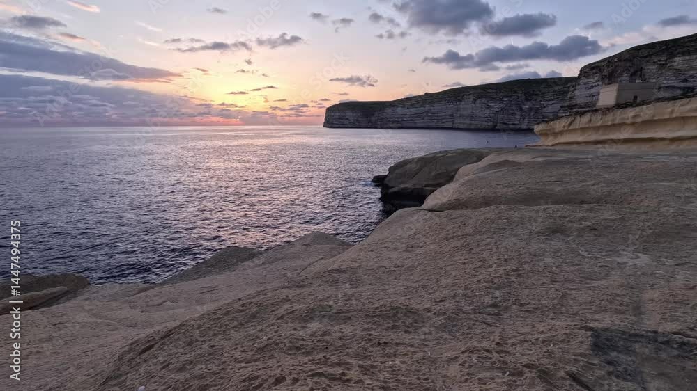 Witness the beautiful sunset over the cliffs and tranquil waters of Malta's coastline Witness the beautiful sunset over the cliffs and tranquil waters of Malta's coastline