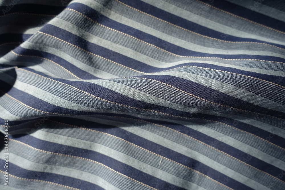 blue and grey striped cotton fabric in soft folds