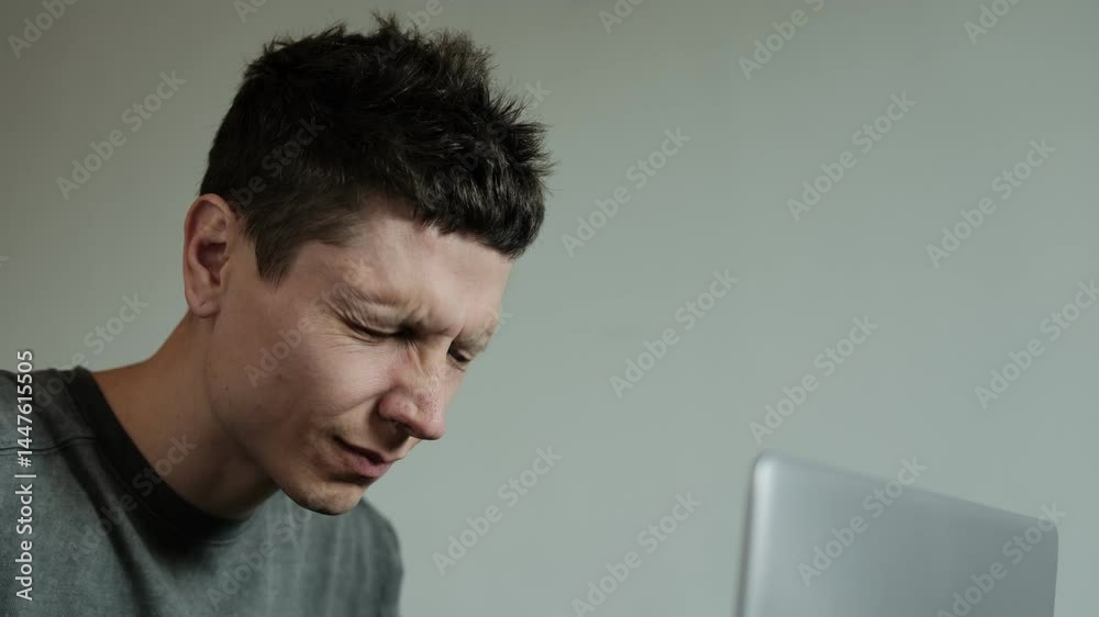 Digital eye strain. Close-up of exhausted young man taking off glasses massaging dry irritable eyes. Tired overworked man feeling eye strain after using computer working from home.