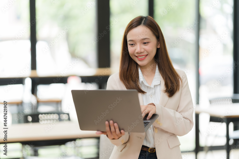 Smiling Businesswoman Using Laptop in Office Smiling Businesswoman Using Laptop in Office