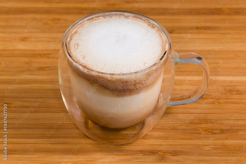 Cappuccino with milk foam in glass double-walled hollow cup Cappuccino with milk foam in glass double-walled hollow cup