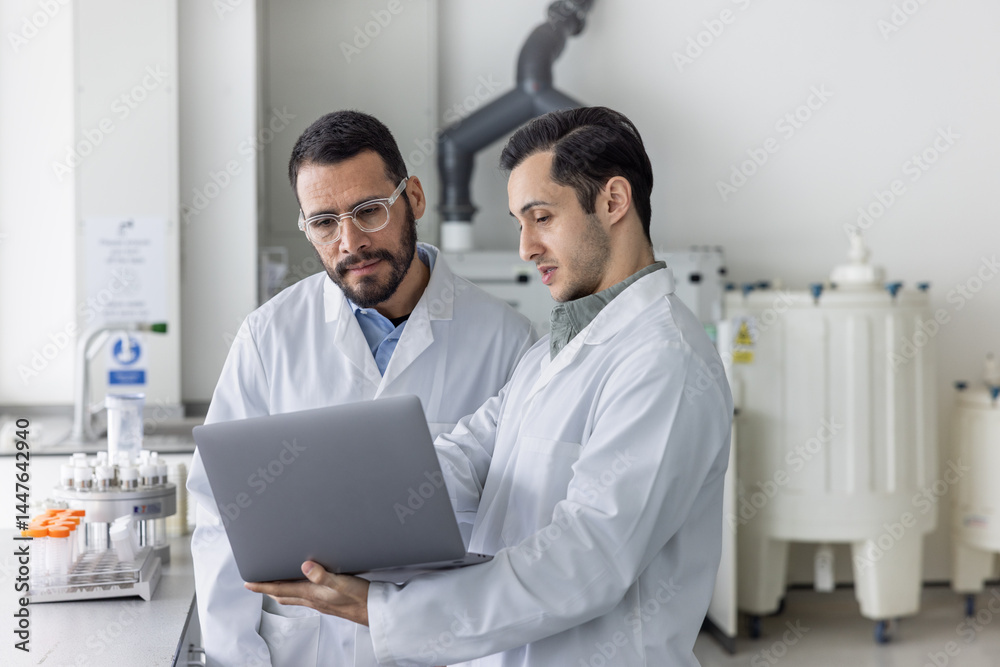 Medical student showing data on a Laptop to his teacher Medical student showing data on a Laptop to his teacher