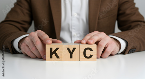 Man Presents Know Your Customer Concept with Wooden Blocks on White Surface in Studio with Brown Blazer
