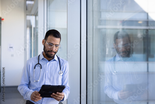 Male doctor reviewing patient data on tablet