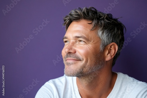 Obraz na płótnie A glowing and peaceful man expressing warmth. Concept layout of style for aging men. Purple solid background. Modish men's side part haircut - midlife white man with hair. w salonie