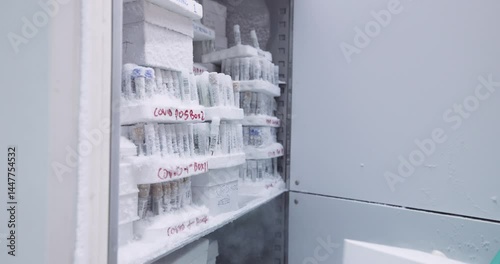 Indian female scientist removing medical samples from a -80deg fridge  in a laboratory