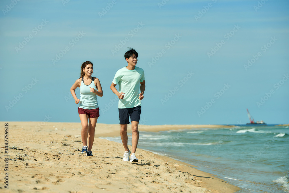 Young Couple Jogging on Sandy Beach Young Couple Jogging on Sandy Beach
