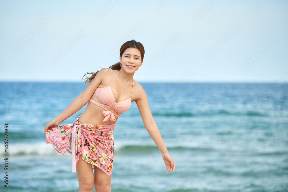 Fototapeta premium Joyful Young Woman Enjoying Beach Breeze