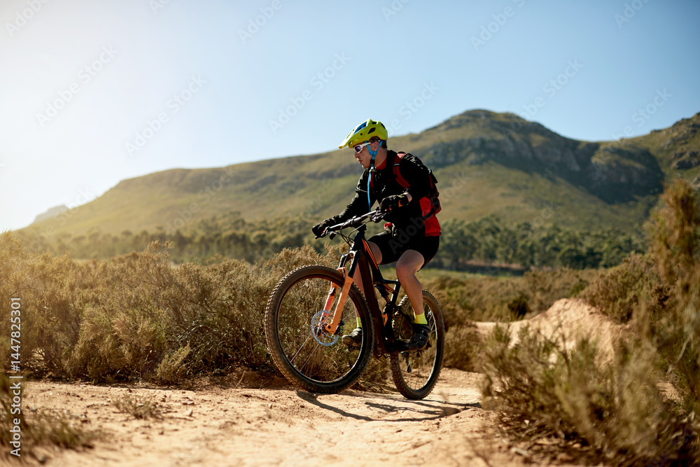 Mountain bike, sports and man riding on dirt road for gravel race, challenge or competition training. Fitness, cycling and athlete cyclist driving on trail outdoor for exercise or workout in nature.