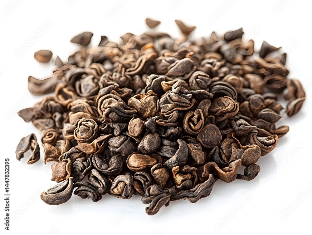 A close-up studio shot shows a pile of dark brown dried tea leaves against a bright white background perfect for packaging design. A close-up studio shot shows a pile of dark brown dried tea leaves against a bright white background perfect for packaging design.