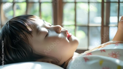 障子越しの朝日に包まれ眠る日本人の子ども