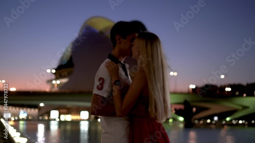 Young Couple staying at night time near the fountain, hugging and kissing in Palau de les Arts