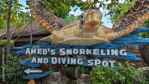 Giant sea turtle statue and Amed's snorkeling and diving spot sign in Bali Indonesia
