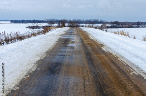 Road maintenance in cold weather conditions with anti-slip treatment during snowfall season.