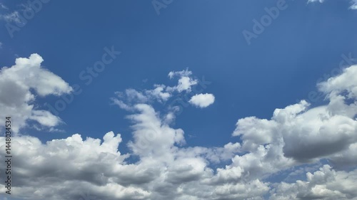 Timelapse of soft white clouds moving clear blue sky