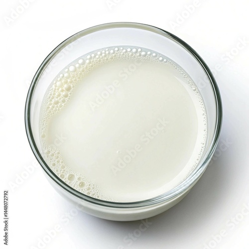 fresh milk in a glass bowl top down view on a white background