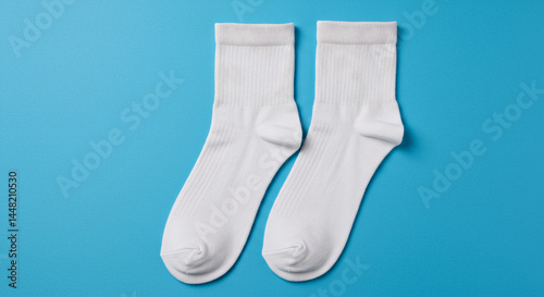 Pair of clean white socks on a vibrant blue background, simple and minimalist.	