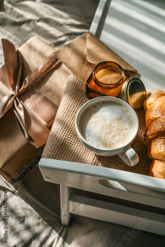 Wallpaper Mural Breakfast in bed with a wrapped gift box, croissant, candle, and cup of coffee on a wooden tray, surrounded by soft bedding and festive balloons in beige and gold tones Torontodigital.ca