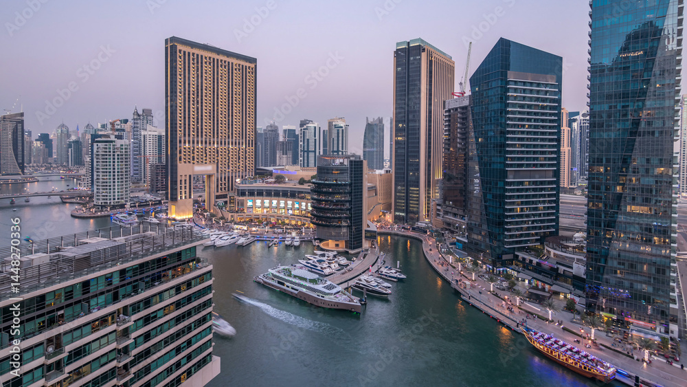 Fototapeta premium Beautiful aerial top view day to night transition timelapse of Dubai Marina canal