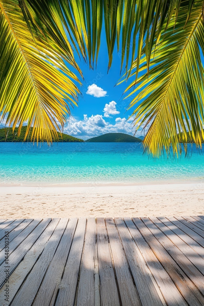 Fototapeta premium Tropical beach view framed by palm leaves, leading to turquoise waters and a distant island. Wooden deck in the foreground