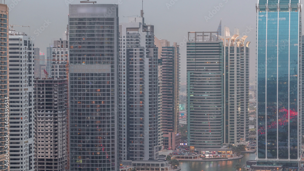 Obraz premium Residential and office buildings in Jumeirah lake towers district day to night timelapse in Dubai