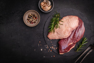 Preparation for cooking raw duck breast with ingredients on dark background, top view. Space for text. High quality photo