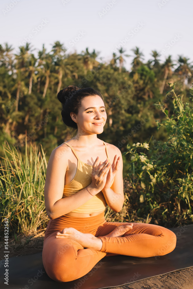 Young woman meditating in Lotus Pose in nature