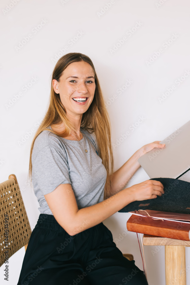 Cheerful woman with laptop in hand