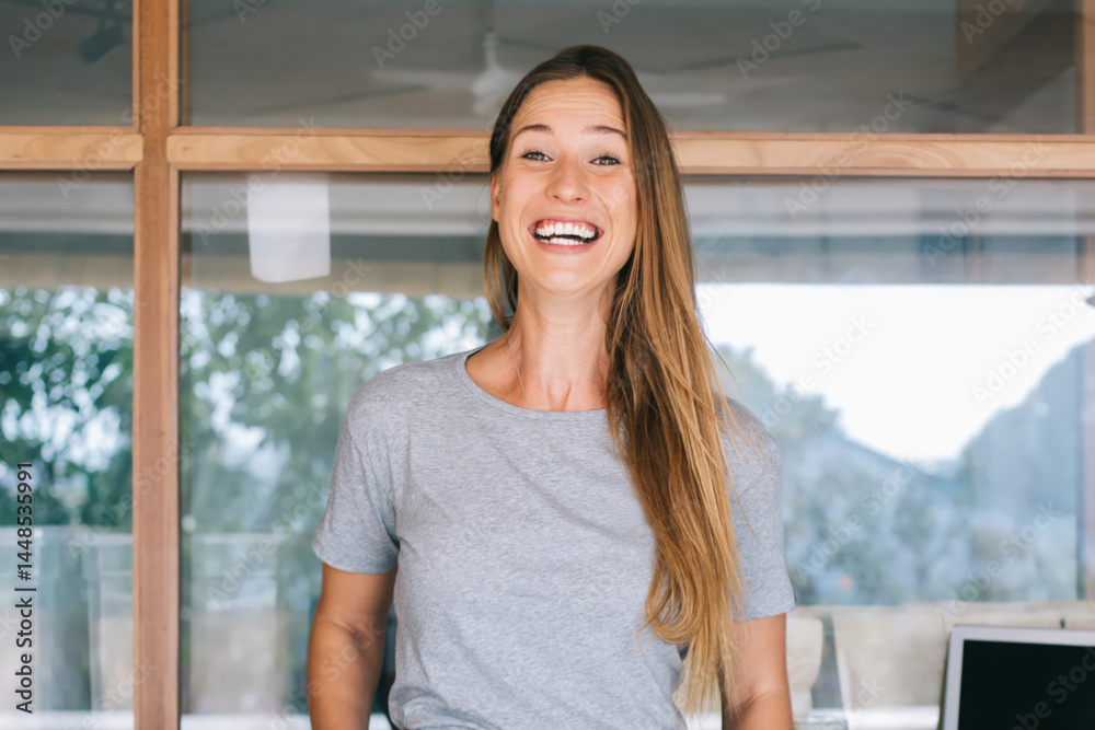 Smiling woman standing near reception in modern office
