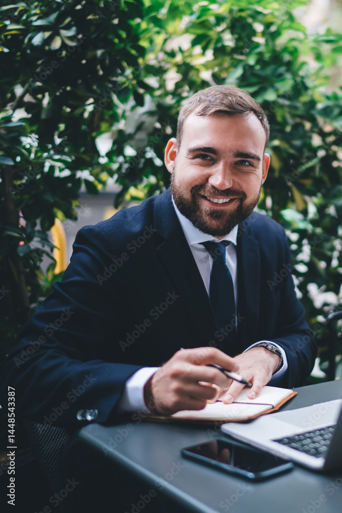 Smiling bearded young male entrepreneur during break