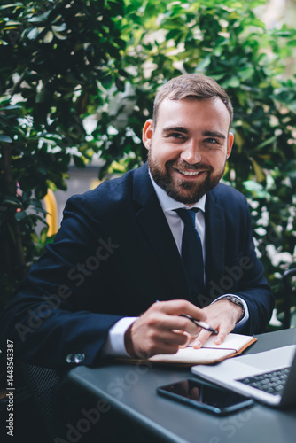 Smiling bearded young male entrepreneur during break
