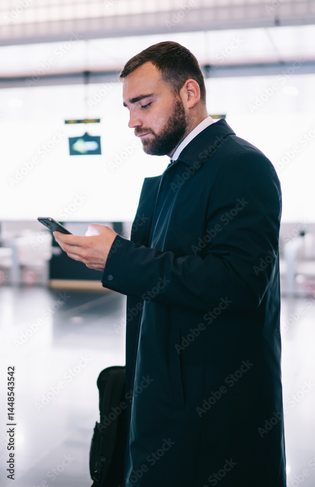Serious man surfing cellphone in airport