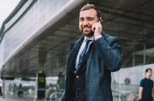 Cheerful entrepreneur speaking on mobile phone on street