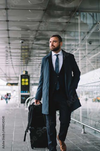 Elegant passenger with luggage walking near airport building
