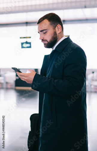 Obraz na płótnie Serious man surfing cellphone in airport w salonie