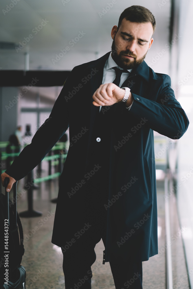Stern man in suit waiting for flight in airport
