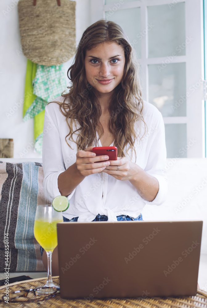 Confident woman messaging on smartphone while resting at home