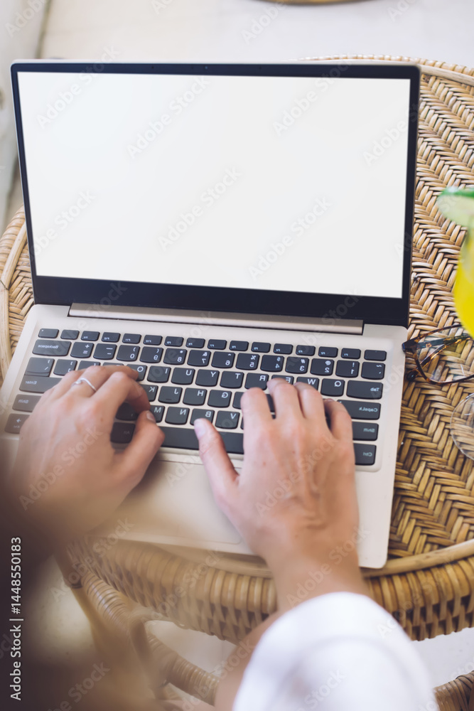 Student typing laptop while drinking juice at home