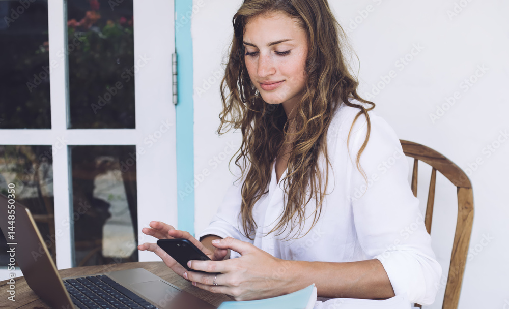 Young woman freelancer smiling and typing on smartphone