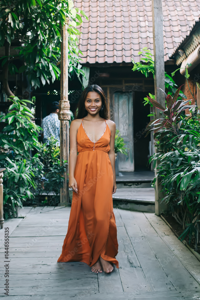 Smiling young ethnic lady in cafe of tropical resort