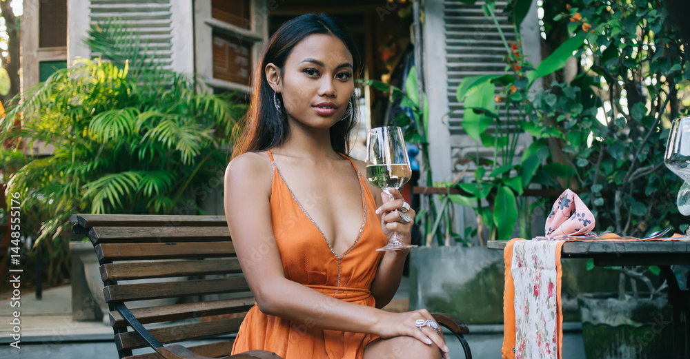 Stylish young ethnic woman drinking drinking wine on terrace of