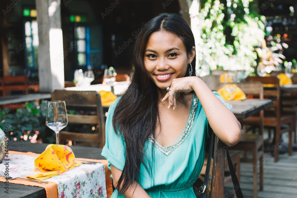 Positive woman sitting in outdoor cafe