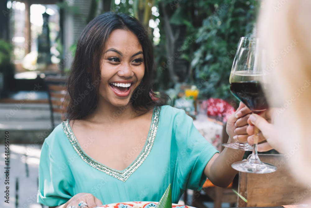 Happy women drinking wine in outdoor cafe