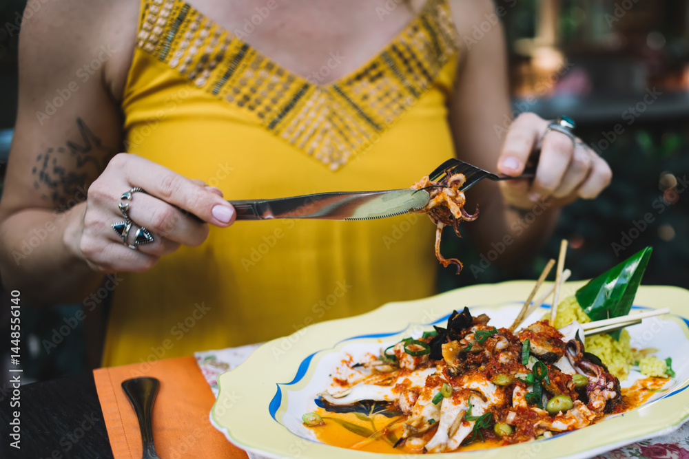 Crop woman eating seafood dish in cafe