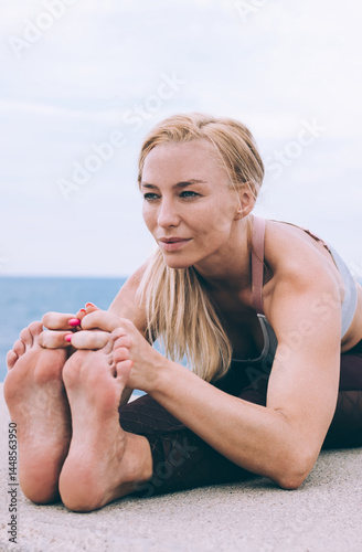 Obraz na płótnie Slender focused sportswoman in yoga pose on coast w salonie